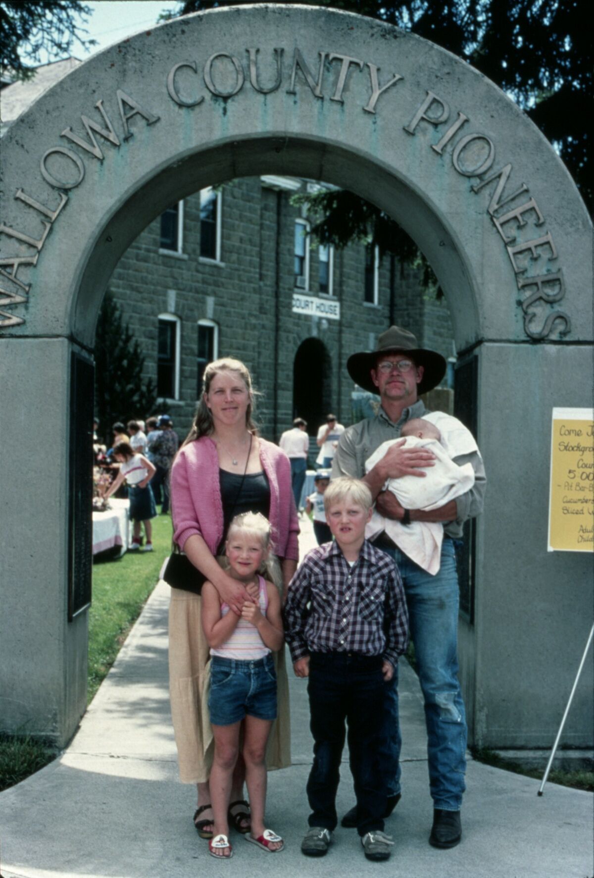 Sarah and Mike Hale stand with their children, Prairie Rose, Gabe, and Zeke, in the Pioneers arch at the Wallowa County Courthouse in Enterprise. Taken by Janie Tippett.